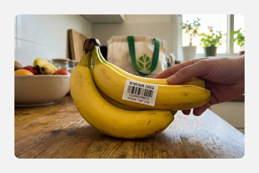 יד מחזיקה אשכול בננות עם מדבקת ברקוד ייעודית "בננה מובחרת" וקוד סריקה.