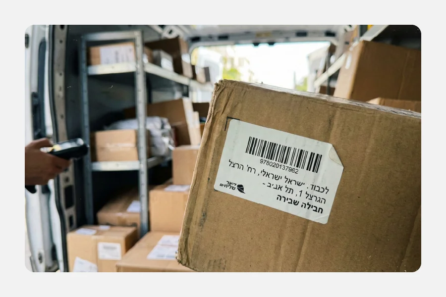 מדבקת ברקוד למשלוח על קרטון בתוך רכב הפצה, ברקוד קריא לסריקה מהירה.