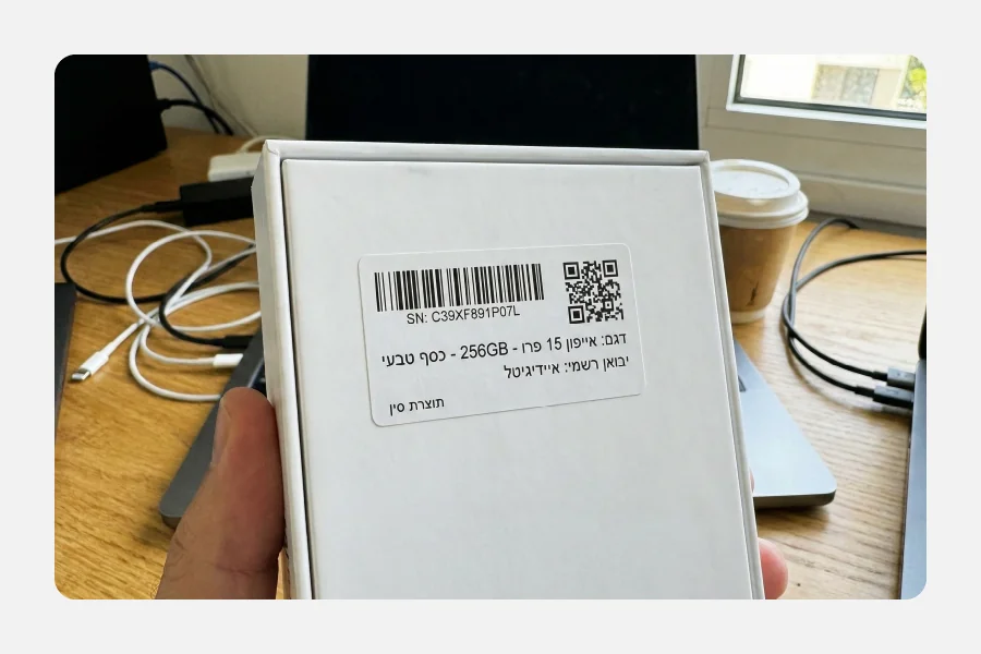 גב אריזת אייפון עם מדבקת ברקוד וקוד QR הכוללת מספר סידורי ופרטי יבואן.